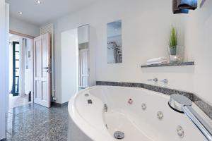 uma casa de banho branca com uma banheira e uma janela em Lister Düne EG em List