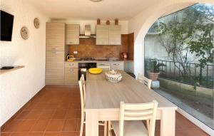 a kitchen with a wooden table and chairs in a room at 2 Bedroom Lovely Apartment In Frigole in Frigole