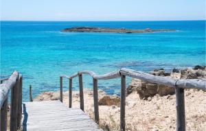 a wooden path to the beach with an island in the background at 2 Bedroom Lovely Apartment In Frigole in Frigole