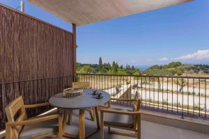 a patio with a table and chairs on a balcony at Pnoes Luxury Suites in Paliouri