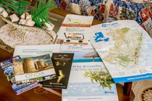 una mesa con un montón de folletos y un mapa en Casa Tere Playa, en Chilches