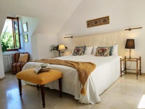 Un dormitorio con una gran cama blanca y una mesa en La Casa de San Fernando con vistas a los Reales Alcázares en Sevilla