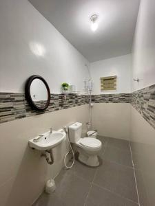 a bathroom with a toilet and a sink and a mirror at Tagaytay Transient House, 4 bedrooms, billiard in Indang