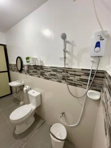 a bathroom with a toilet and a shower in it at Tagaytay Transient House, 4 bedrooms, billiard in Indang