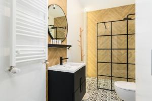 a bathroom with a sink and a mirror at Family Apartment 62m - Sowia with GARAGE & BALCONY by Renters in Poznań