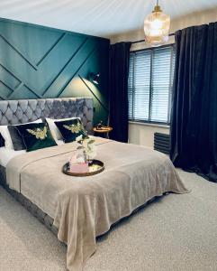 um quarto com uma cama grande e uma parede azul em Cuckoo Rooms em Colchester
