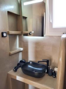 um lavatório preto num balcão numa cozinha em Thermyes Villas 3 em Kythnos