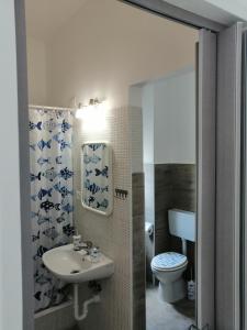 uma casa de banho com um lavatório e um WC em Albergo blue fish em Albisola Superiore