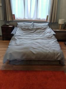 an unmade bed in a bedroom with a window at self contained flat in Llanfyllin Powys in Llanfyllin