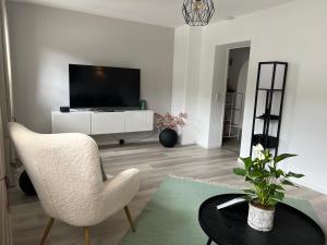 uma sala de estar com uma televisão, uma cadeira e uma mesa em Ferienwohnung Kohl - Malerhäusl - Berchtesgaden em Berchtesgaden