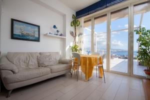 a living room with a table and a couch at Limoni Sul Mare in Torre Faro