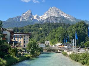 eine Brücke über einen Fluss mit einem Berg im Hintergrund in der Unterkunft Ferienwohnung Kohl - Malerhäusl - Berchtesgaden in Berchtesgaden