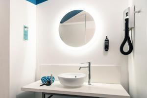 a white bathroom with a sink and a mirror at ibis Styles Toulon Centre Port in Toulon