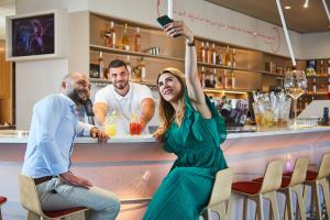a woman sitting at a bar with her hand in the air at ibis Styles Toulon Centre Port in Toulon