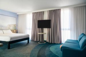 a hotel room with a bed and a blue couch at ibis Styles Toulon Centre Port in Toulon +37 photos