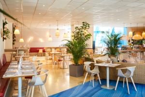 a restaurant with tables and chairs and plants at ibis Styles Toulon Centre Port in Toulon