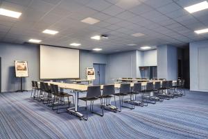 a conference room with tables and chairs and a whiteboard at ibis Styles Toulon Centre Port in Toulon