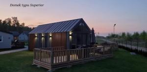 una casa con techo de gambrel en la hierba en LUXURY CAMP - 150 m od Suntago Park en Grabce