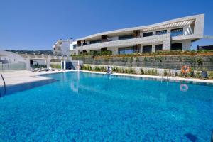 einem großen Pool vor einem Gebäude in der Unterkunft Real de La Quinta Quercus Serenity Luxury Seaview Apartment Marbella in Benahavís