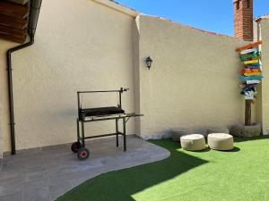 eine Terrasse mit einem Tisch und grünem Gras in der Unterkunft Casa Aurora in Sanchidrián