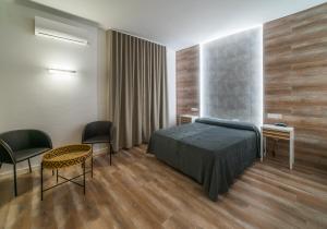 um quarto com uma cama, uma mesa e cadeiras em Hotel Casa Lorenzo em Villarrobledo