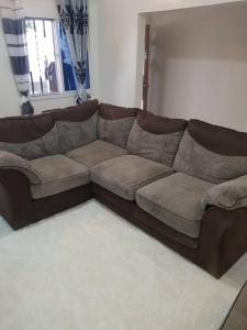 un divano marrone in soggiorno di Tapis Guest House a Brikama