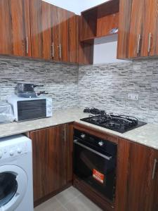 a kitchen with a stove top oven next to a sink at Tapis Guest House in Brikama