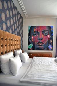 a hotel room with a bed, television and paintings on the wall at Pension fürDich in Zurich