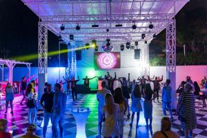 a group of people dancing on a stage at night at AQI Hydros Club in Kemer