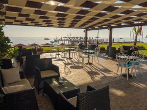 a patio with tables and chairs and the ocean at AQI Hydros Club in Kemer