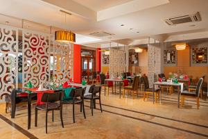a restaurant with tables and chairs in a room at AQI Hydros Club in Kemer