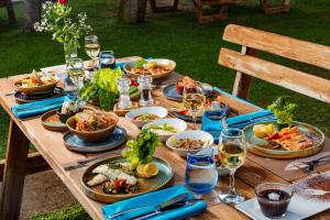 a wooden table with plates of food and glasses of wine at AQI Hydros Club in Kemer