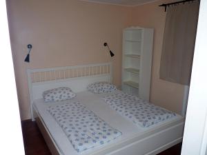 a bedroom with a bed with blue and white pillows at Levendula apartman in Kehidakustány