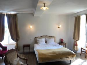 a bedroom with a bed and two windows at Ancien hôtel aux moines Pierrefitte St Lo in Saint Lo