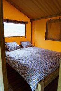 - une petite chambre avec un lit et une fenêtre dans l'établissement LE LODGE DU DOMAINE, à Saint-Hilaire-en-Morvan