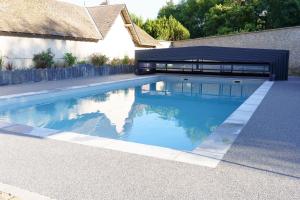 - une piscine en face d'une maison dans l'établissement LE LODGE DU DOMAINE, à Saint-Hilaire-en-Morvan