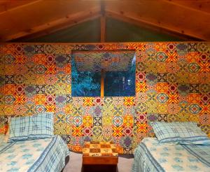 a room with two beds and a colorful wall at Fighting Kangaroo Camp in Dahab