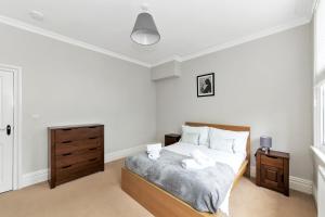 a bedroom with a bed and a wooden dresser at Derby City Centre, Bright, Spacious, and Airy Apartments - 112 Duffield Road in Derby