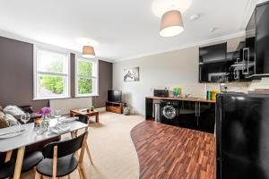 a kitchen and living room with a table and a dining room at Derby City Centre, Bright, Spacious, and Airy Apartments - 112 Duffield Road in Derby