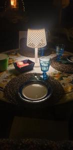 una mesa con una placa y una lámpara. en Il Belvederino, en Brufa