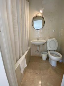 a bathroom with a toilet and a sink and a mirror at Hostal Residencia Alma in Port d'Alcudia