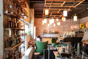 a restaurant with a bar with green chairs at BIG MAMA Berlin in Berlin