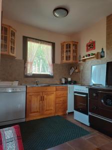 a kitchen with white appliances and a window in it at Green Eco Cottage in Kolašin