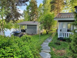 una casa de campo con un camino junto a una casa en Mökki ja rantasauna Saimaan rannalla en Taipalsaari