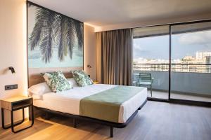 a bedroom with a bed and a large window at Hotel Primavera Park in Benidorm