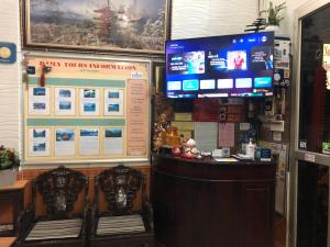 a restaurant with a bar with two chairs and a television at North Hostel N.2 in Hanoi