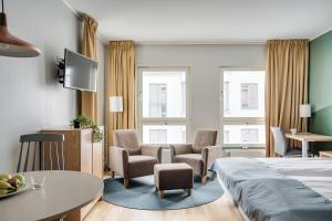 une chambre d'hôtel avec un lit, des chaises et une table dans l'établissement Forenom Aparthotel Lund, à Lund