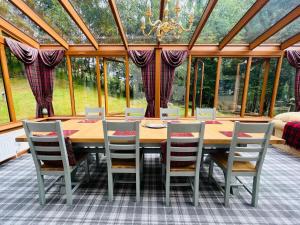 a dining room with a wooden table and chairs at Tarmachan Cottage - West Highland Getaway in Fort William