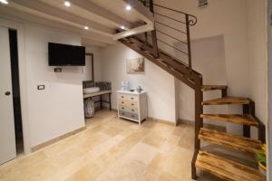 蓬塔蒲爾修多的住宿－Il Casale di Punta Prosciutto，阁楼卧室设有螺旋楼梯和书桌