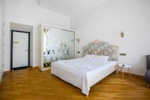 a bedroom with a white bed with a large headboard at KayKay Apartments in Odesa